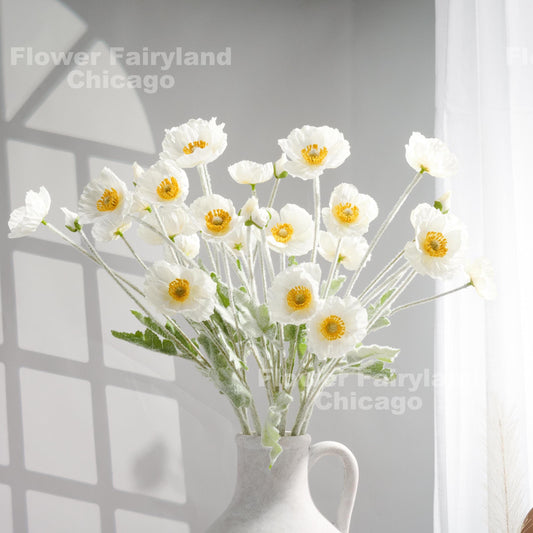 White faux poppy stems in a vase