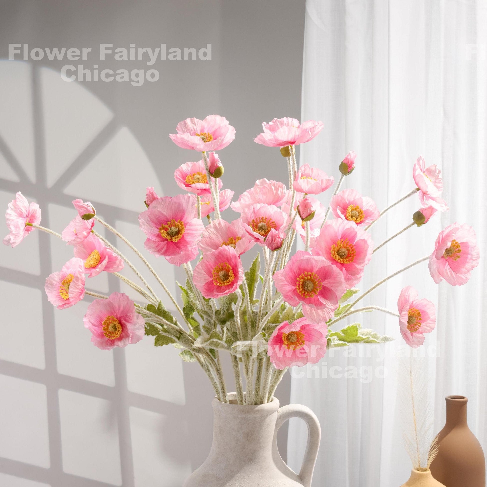 Pretty pink faux poppy stems in a vase