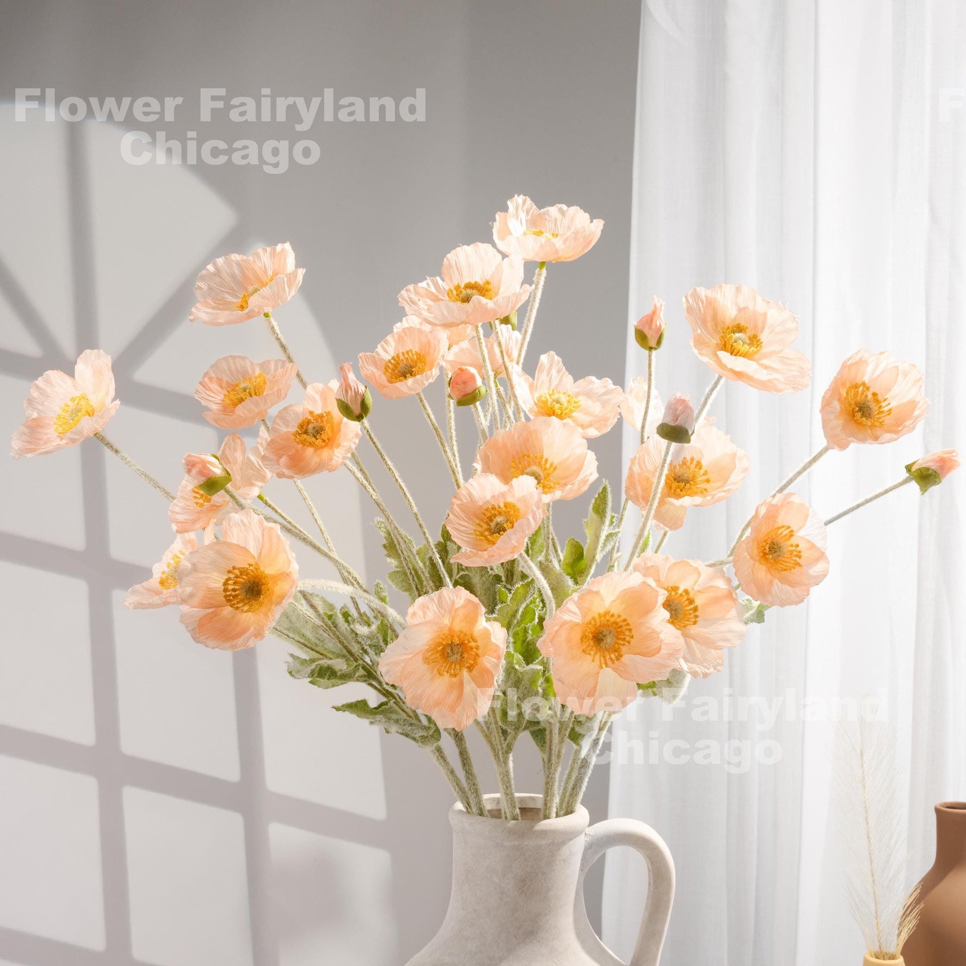 Peach faux poppy stems in a vase