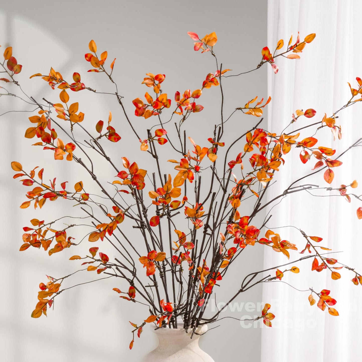 Autumn orange leaf branch arrangement in vase