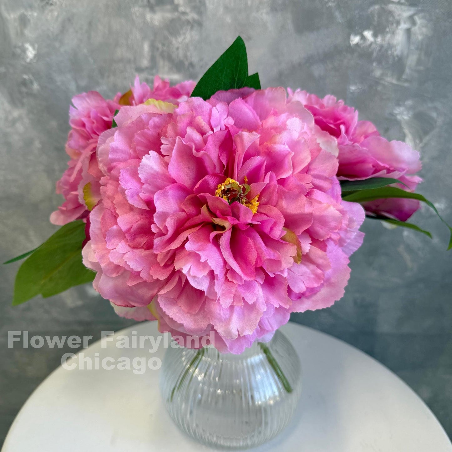 Bright pink huge peonies styled in a vase