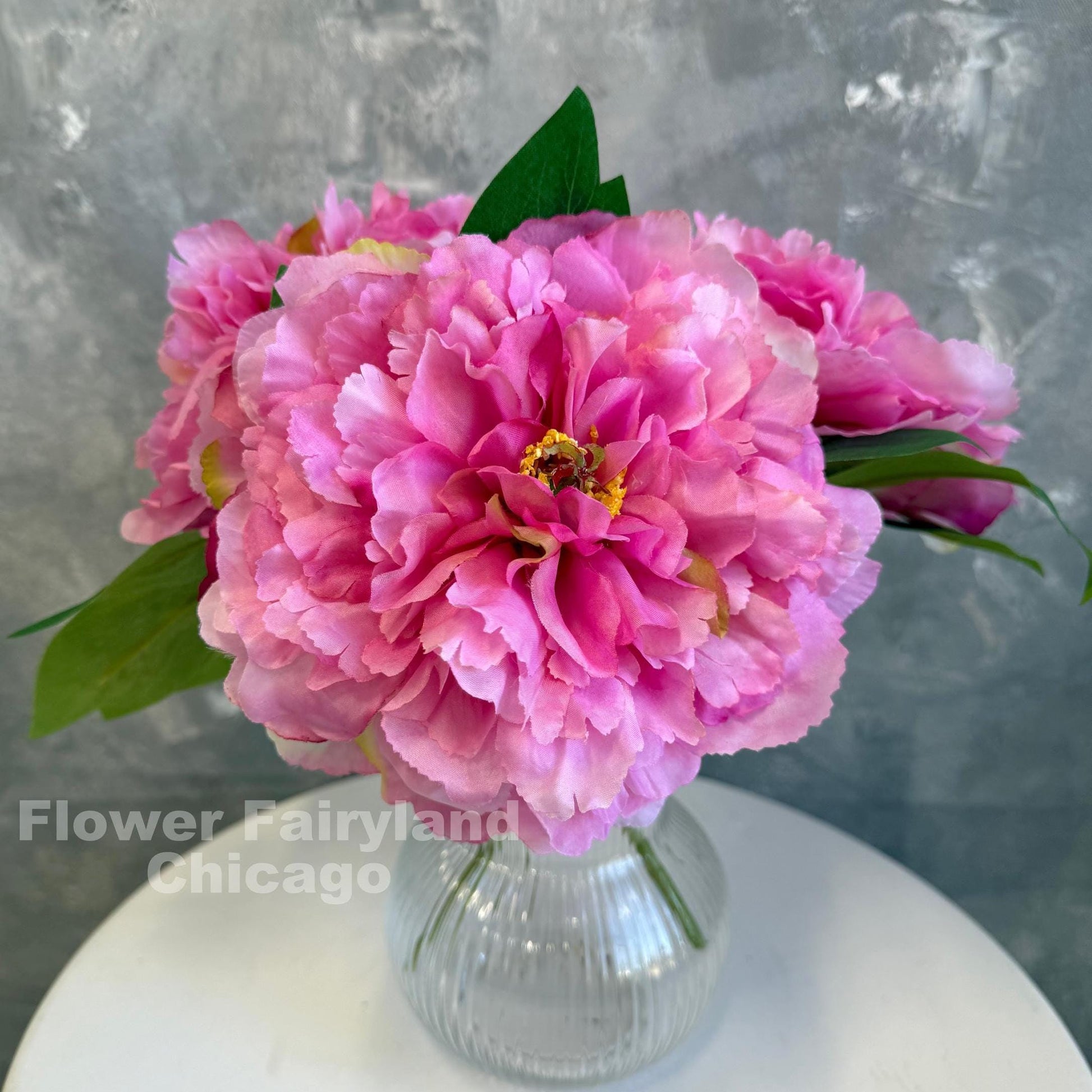 Bright pink huge peonies styled in a vase