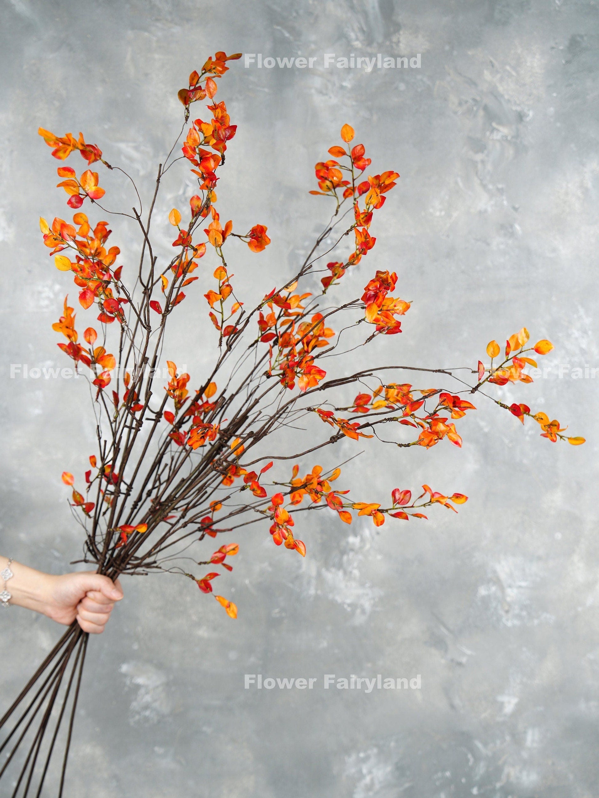 39 inch faux decorative leaf branches in orange held as a bouquet