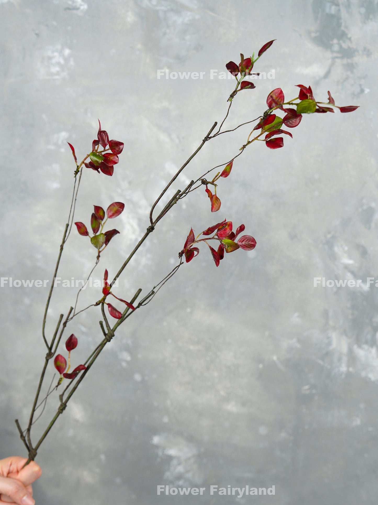 39 inch faux decorative leaf branch in burgundy held in hand