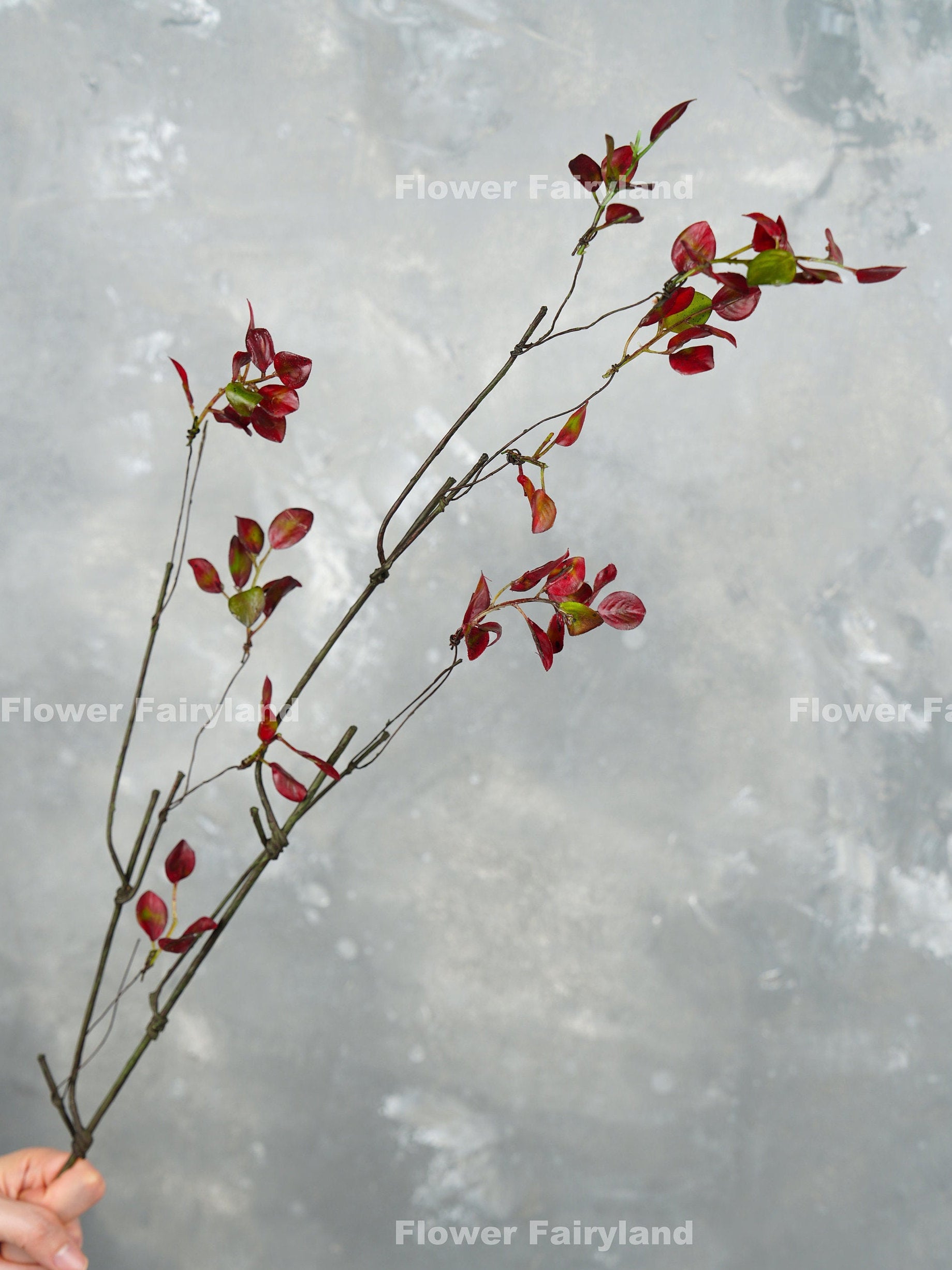 39 inch faux decorative leaf branch in burgundy held in hand