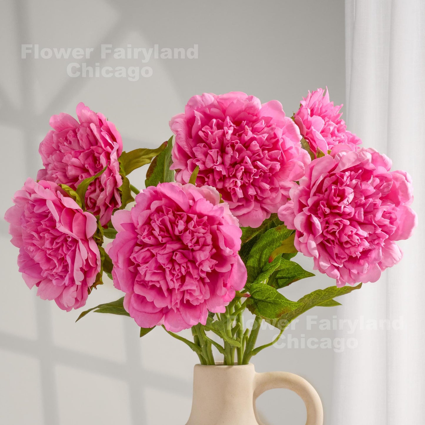 Pink real touch peonies arranged in a cream vase