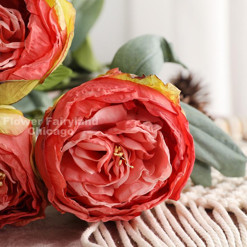 Coral red dried look peony and rose bouquet in a vase