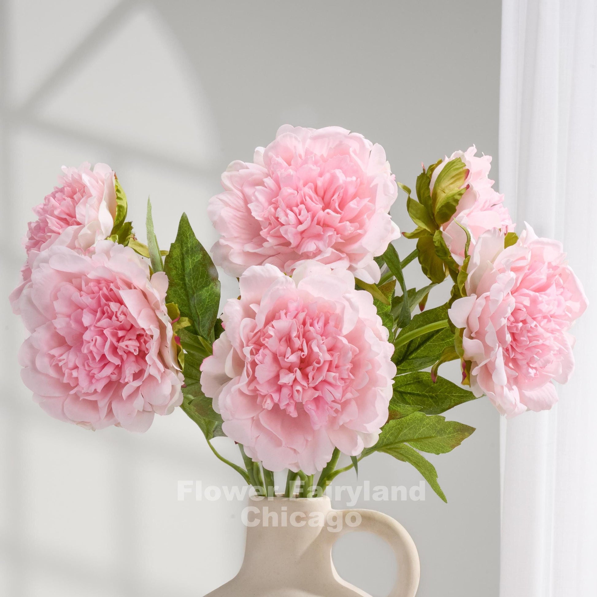 Baby pink real touch peonies arranged in a cream vase