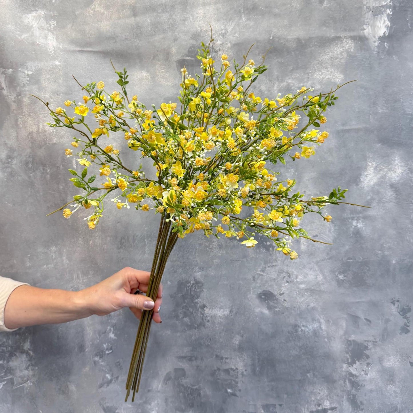 Yellow faux wax flowers styled in a vase