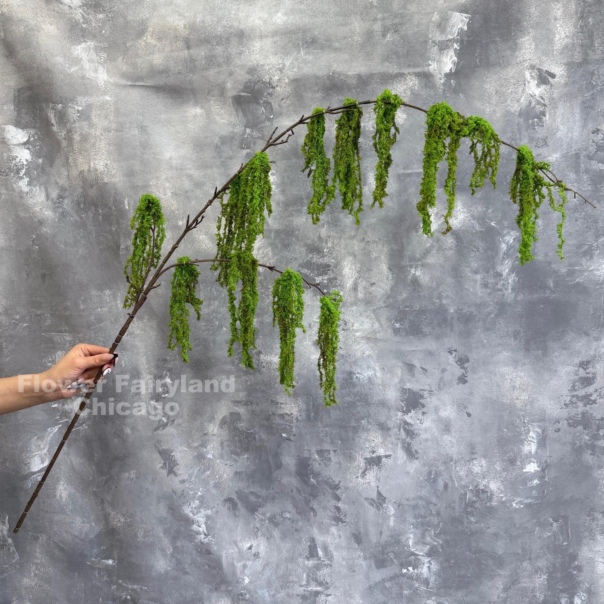 Faux weeping moss branch close-up
